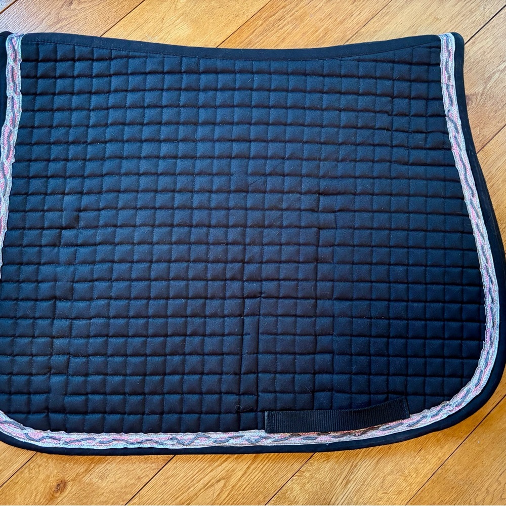 Quilted black saddle pad with pink, gray and silver braided trim.